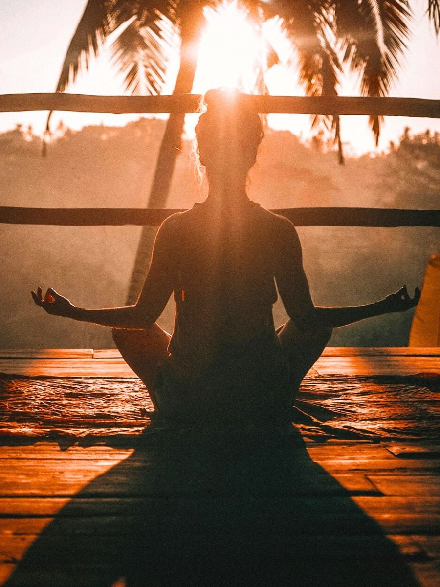 A person sitting calmly in soft, warm light during a moment of quiet reflection